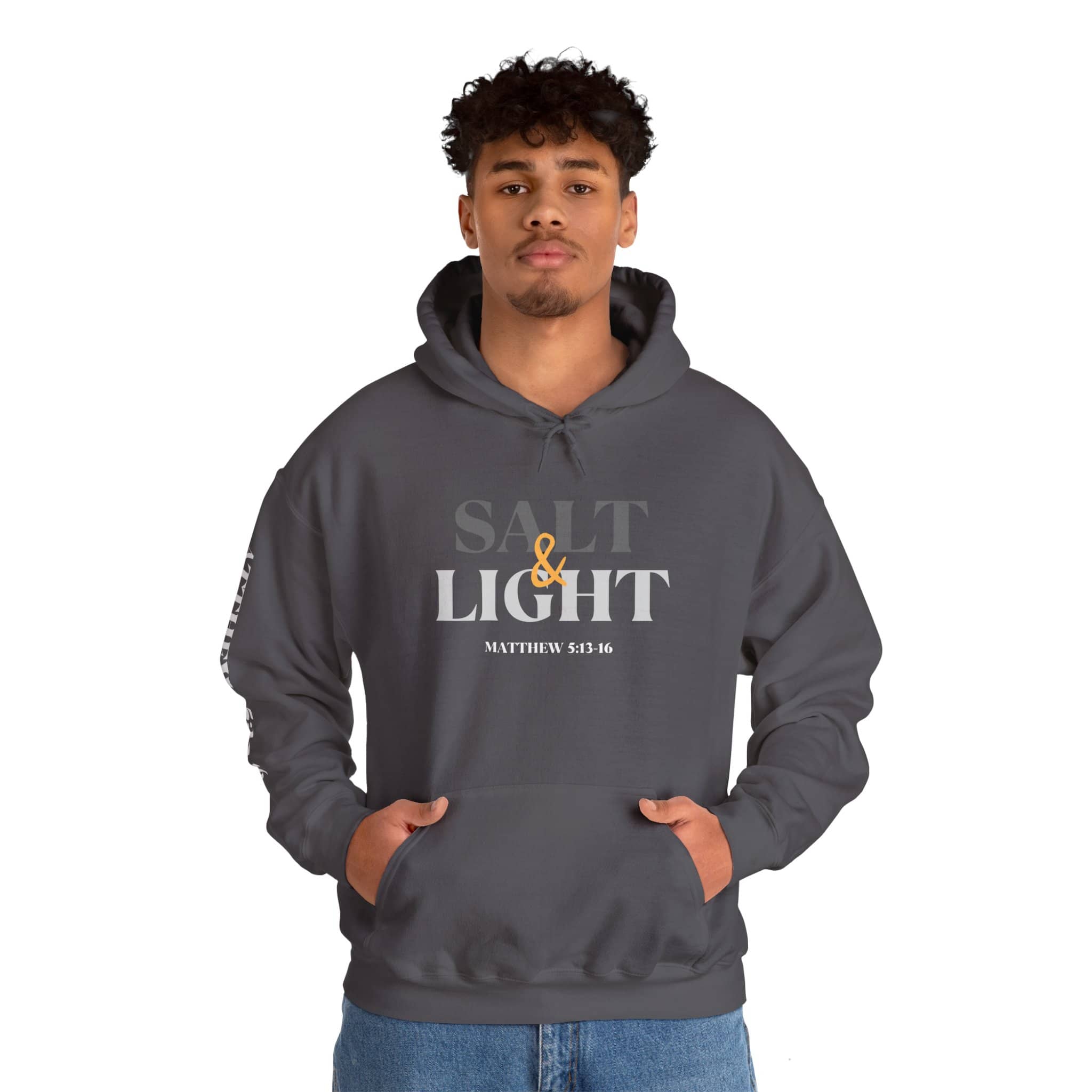 Salt and Light scripture hoodie featuring the front design in charcoal on a man with both hands in the kangaroo pocket