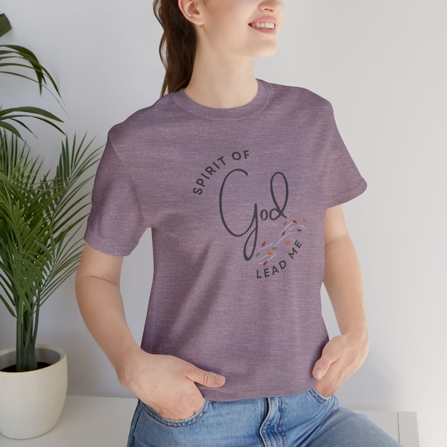 Woman wearing a purple Spirit Lead Me shirt with God inspired text and floral design printed on front