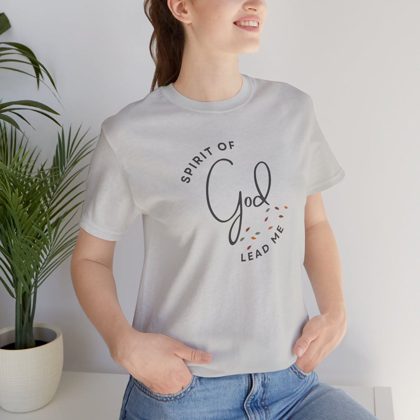 Light gray Spirit Lead Me shirt by Logos with Romans 8:14 text and decorative design worn by woman