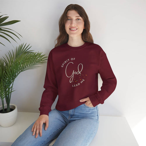 Woman wearing maroon Spirit Lead Me sweatshirt with God lettering sitting near a plant