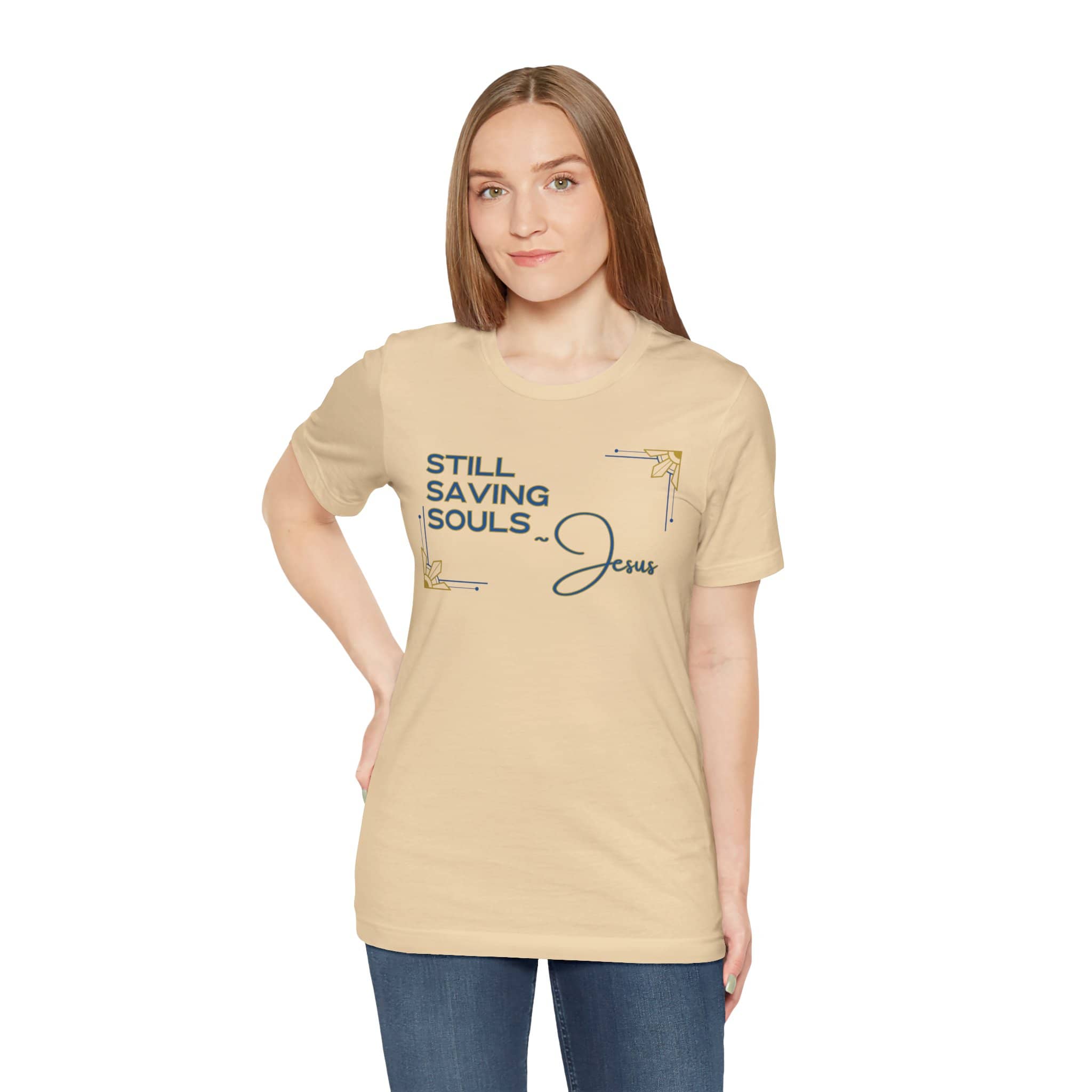 Woman wearing beige Still Saving Souls shirt with Jesus graphic in blue and gold accents