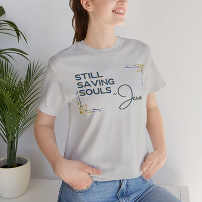 Light gray Still Saving Souls shirt worn by a woman with hands in pockets