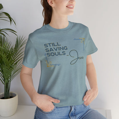Light blue Still Saving Souls shirt by Logos Co. with inspirational Jesus text worn by smiling woman
