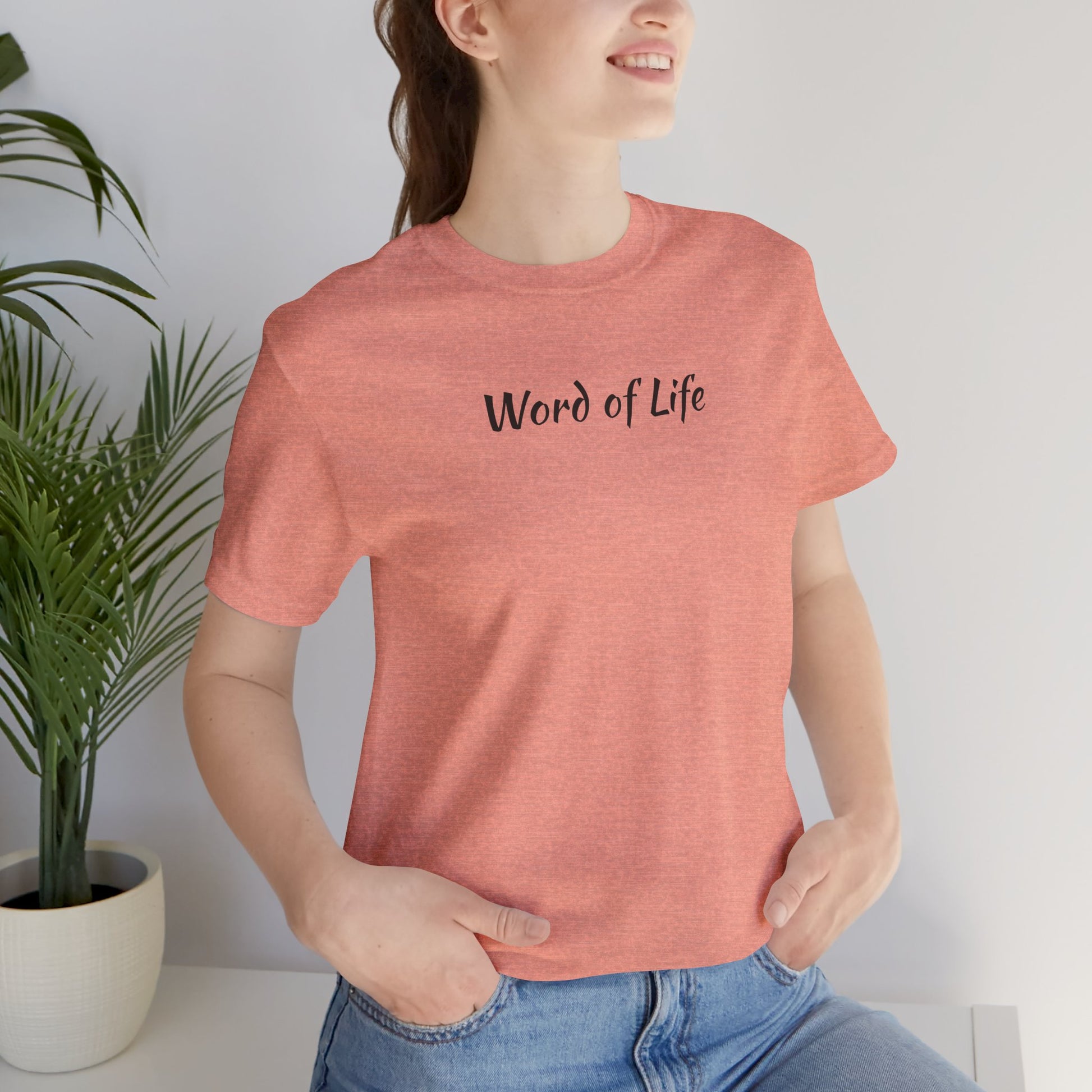 Woman wearing a pink Word of Life Christian shirt from Logos with casual blue jeans